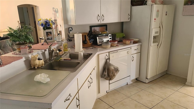 kitchen with white cabinetry, sink, light tile patterned floors, and white appliances