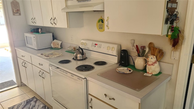 kitchen with white appliances, light tile patterned floors, and white cabinets