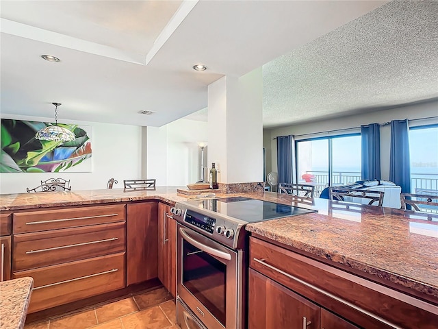 kitchen with electric stove, plenty of natural light, and light stone counters