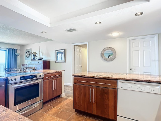 kitchen with tile patterned floors, dishwasher, light stone counters, a textured ceiling, and stainless steel range with electric cooktop