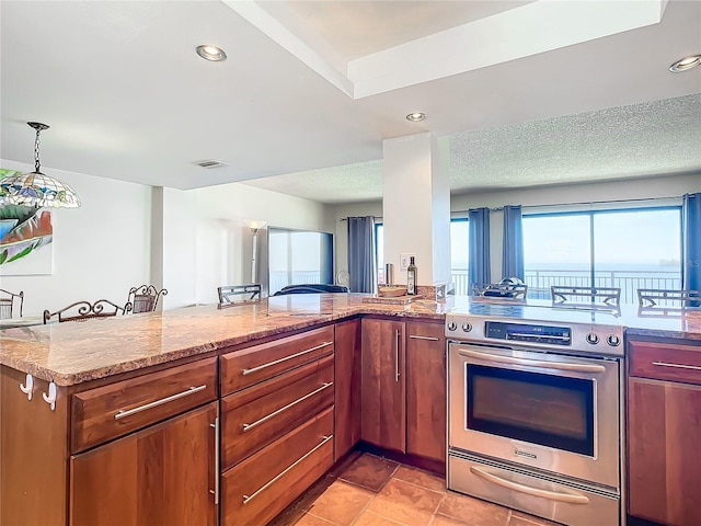 kitchen with electric stove, pendant lighting, light stone countertops, a textured ceiling, and kitchen peninsula