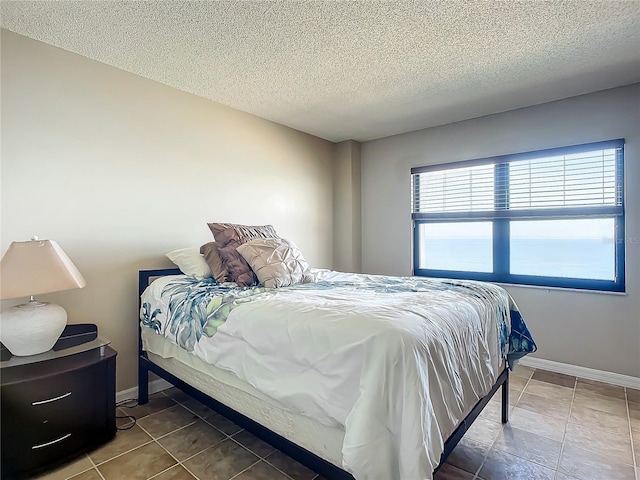 tiled bedroom featuring a textured ceiling