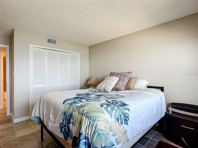 tiled bedroom featuring a closet and a textured ceiling