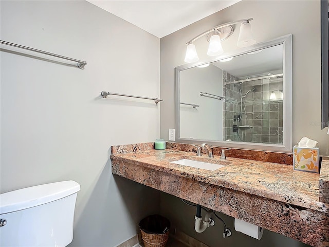 bathroom featuring toilet, sink, and a tile shower