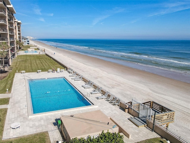 view of pool with a water view, a beach view, and a patio