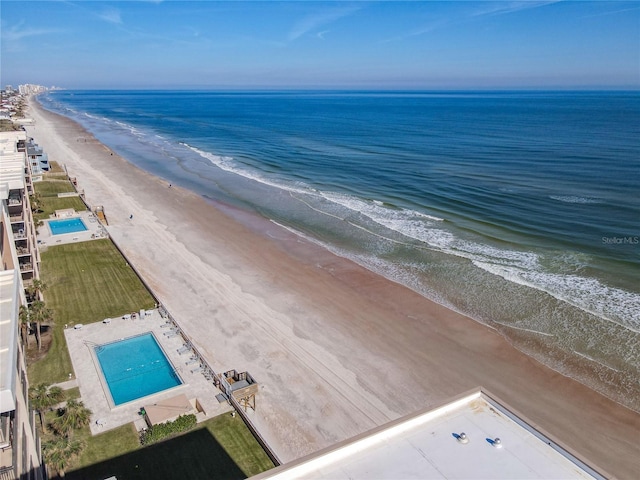 birds eye view of property with a water view and a beach view