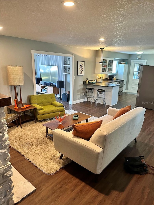 living room featuring dark wood-type flooring and a textured ceiling