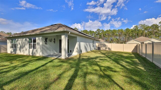 exterior space with central AC and a lawn