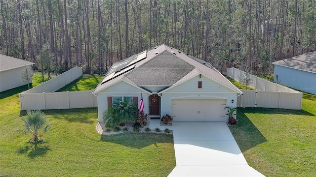 view of front of home featuring a garage, a front yard, and solar panels