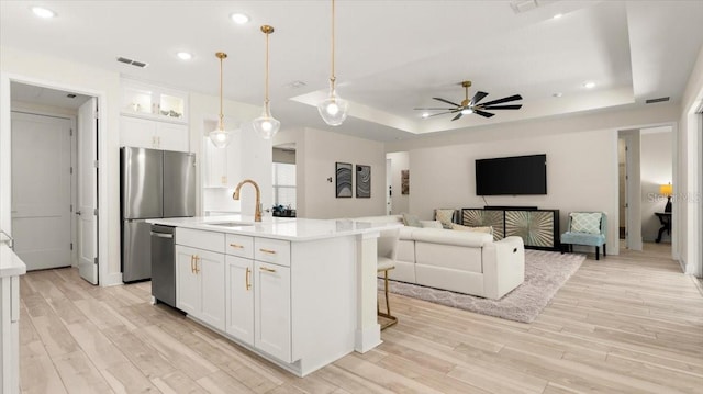 kitchen featuring white cabinetry, appliances with stainless steel finishes, sink, and an island with sink