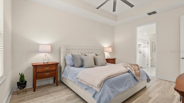 bedroom with ensuite bathroom, ceiling fan, and light wood-type flooring