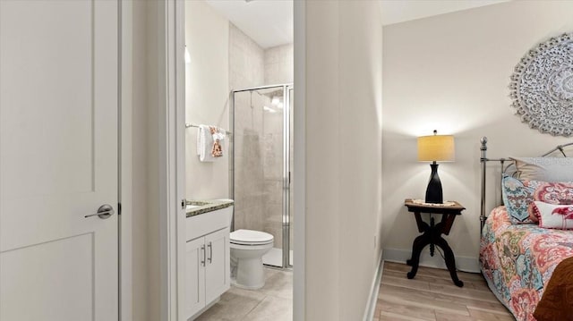 bathroom featuring vanity, hardwood / wood-style flooring, toilet, and walk in shower