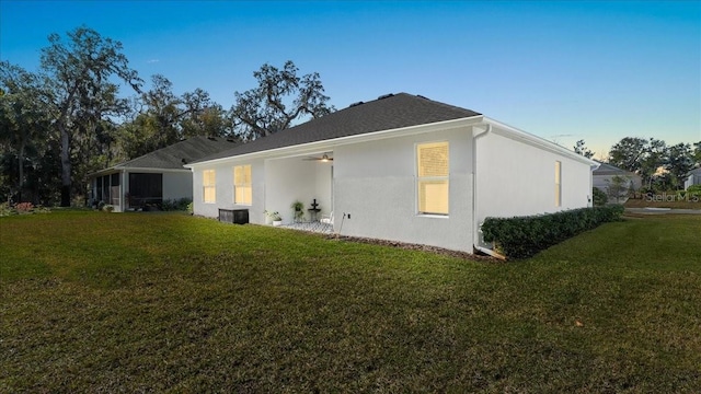 back of house featuring central AC and a lawn