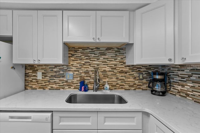 kitchen featuring dishwasher, sink, decorative backsplash, and white cabinets