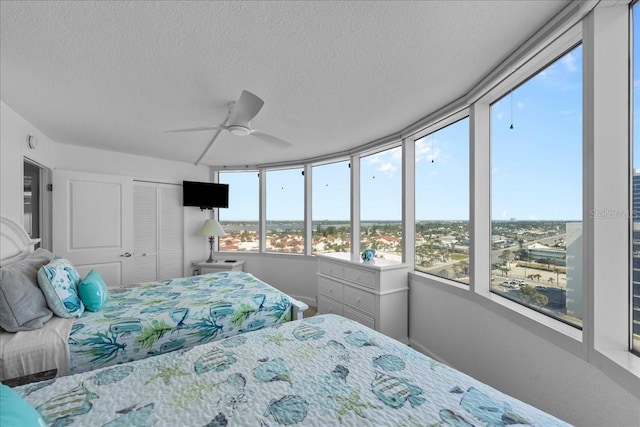 bedroom with ceiling fan, a closet, and a textured ceiling