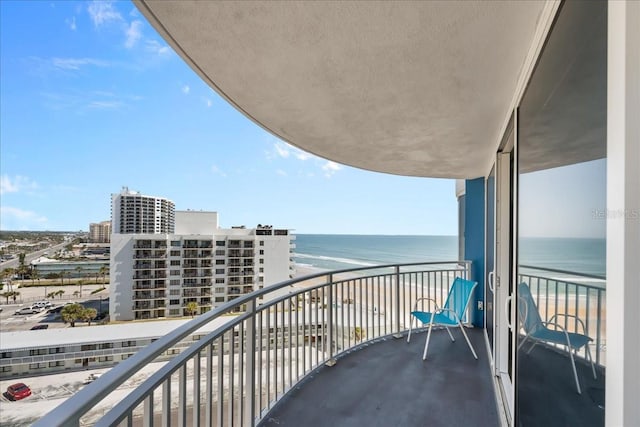 balcony featuring a water view and a view of the beach