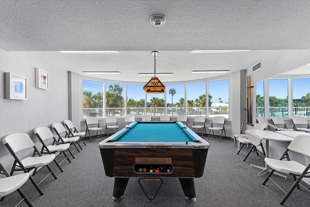 rec room with pool table, a textured ceiling, and dark colored carpet