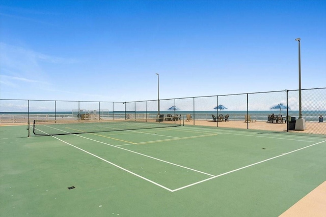 view of tennis court featuring a water view