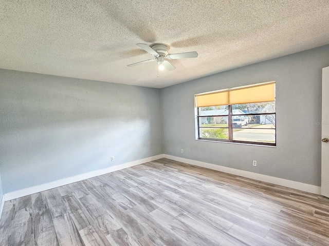 empty room featuring ceiling fan, light hardwood / wood-style floors, and a textured ceiling