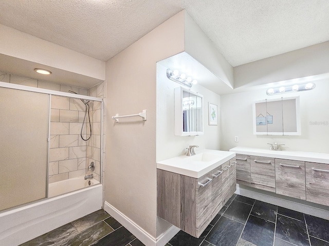 bathroom featuring vanity, bath / shower combo with glass door, and a textured ceiling