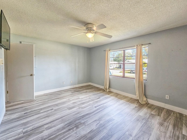 spare room with ceiling fan, light hardwood / wood-style flooring, and a textured ceiling