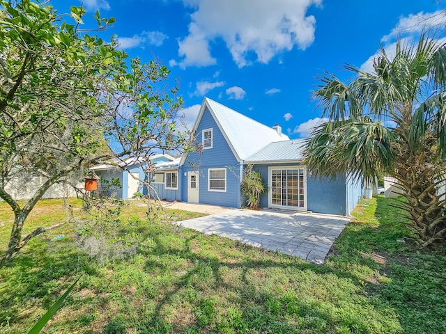 rear view of house featuring a yard and a patio area