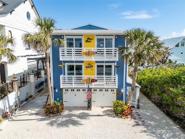 coastal inspired home featuring a garage and a balcony