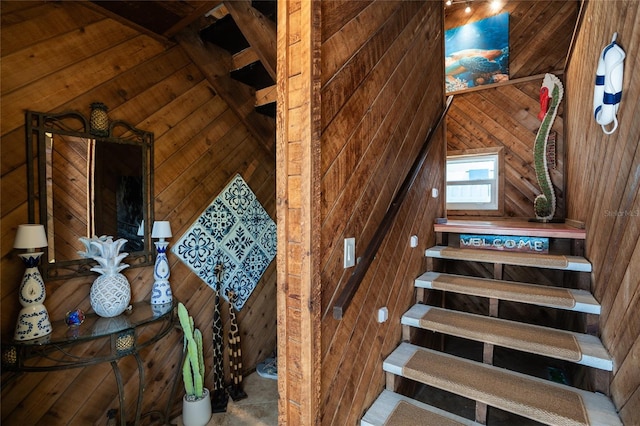 staircase featuring wooden walls