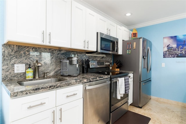 kitchen featuring appliances with stainless steel finishes, sink, white cabinets, dark stone counters, and crown molding