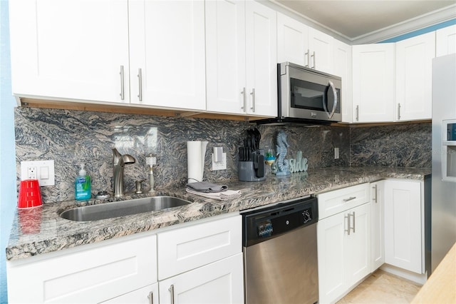 kitchen with sink, stone countertops, appliances with stainless steel finishes, decorative backsplash, and white cabinets