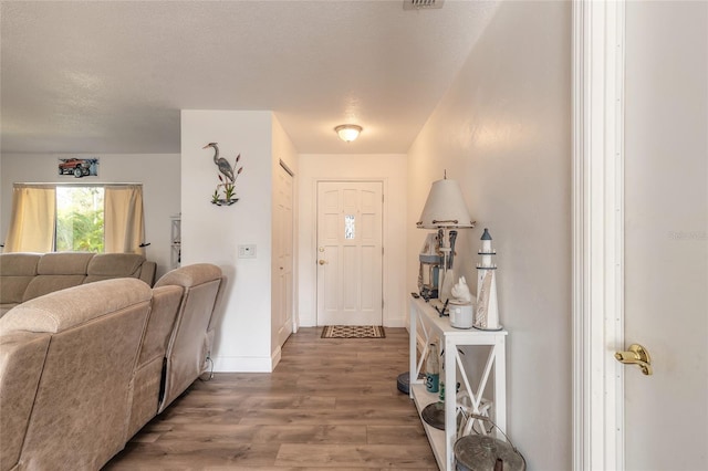 foyer entrance with hardwood / wood-style floors and a textured ceiling