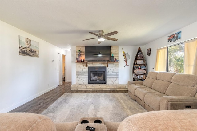 living room featuring wood-type flooring, ceiling fan, and a fireplace