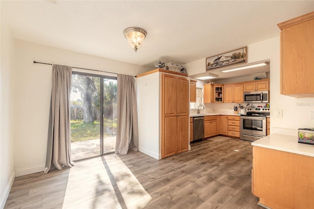 kitchen featuring stainless steel appliances, hardwood / wood-style flooring, sink, and a textured ceiling