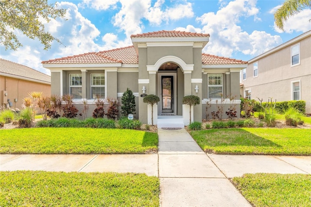 mediterranean / spanish-style home featuring a front lawn