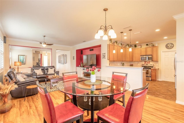 dining room with crown molding, ceiling fan with notable chandelier, and light wood-type flooring