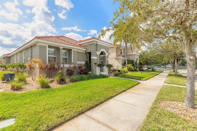 mediterranean / spanish home with a front lawn