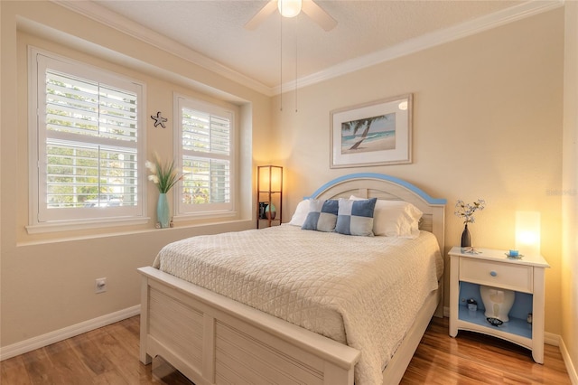 bedroom featuring hardwood / wood-style flooring, ornamental molding, and ceiling fan