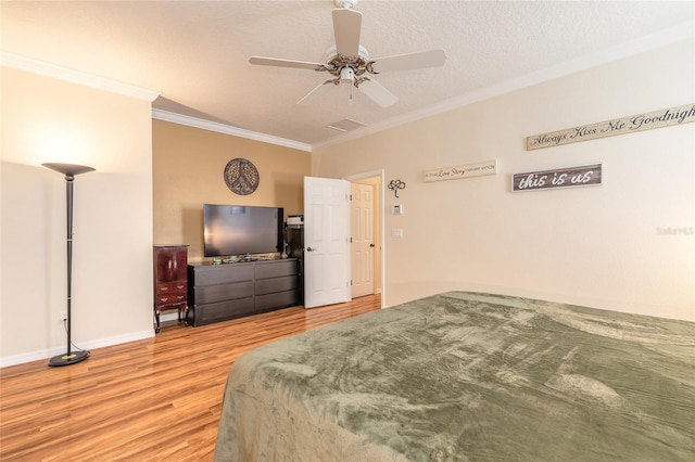 bedroom featuring crown molding, ceiling fan, light hardwood / wood-style flooring, and a textured ceiling