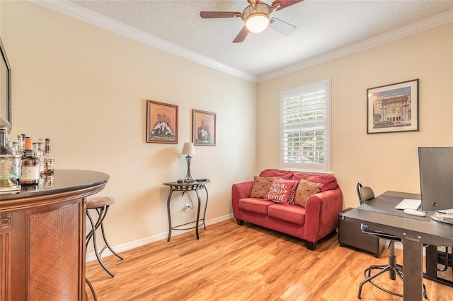 office featuring crown molding, a textured ceiling, light wood-type flooring, indoor bar, and ceiling fan