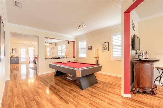 recreation room with crown molding, a textured ceiling, and light hardwood / wood-style flooring