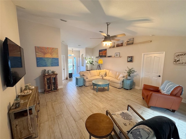 living room with ceiling fan, vaulted ceiling, and light wood-type flooring