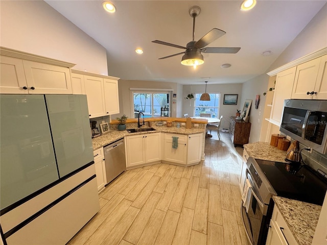 kitchen with sink, vaulted ceiling, light hardwood / wood-style flooring, kitchen peninsula, and stainless steel appliances