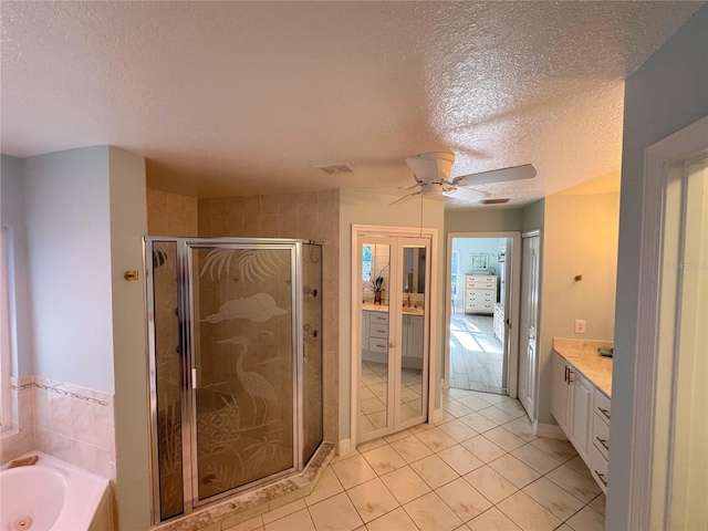 bathroom with tile patterned flooring, vanity, separate shower and tub, and a textured ceiling