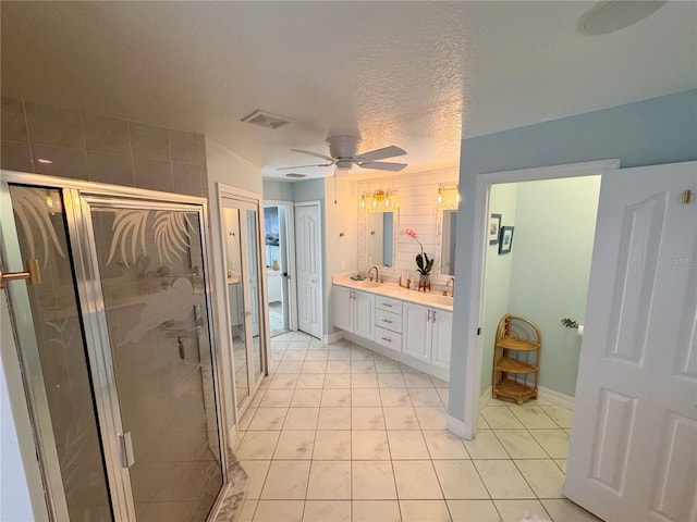 bathroom with tile patterned flooring, vanity, an enclosed shower, ceiling fan, and a textured ceiling