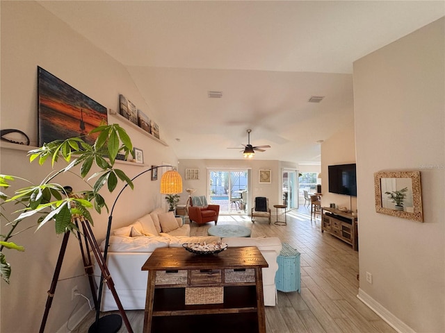 living room with hardwood / wood-style flooring, lofted ceiling, and ceiling fan