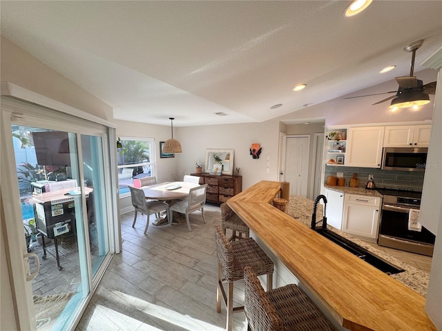 dining space with lofted ceiling, sink, and ceiling fan