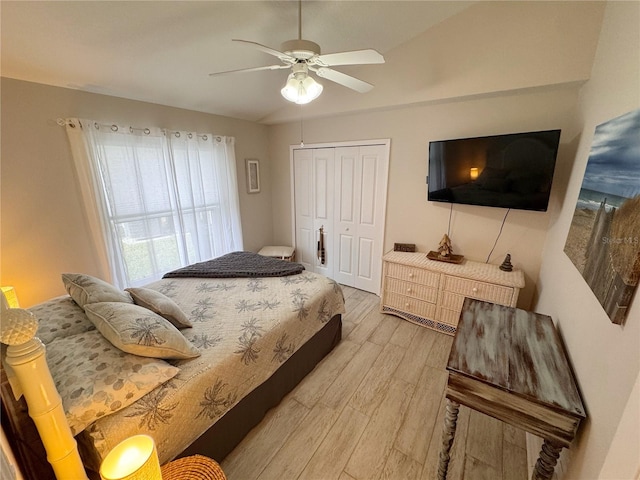 bedroom featuring hardwood / wood-style flooring, vaulted ceiling, ceiling fan, and a closet