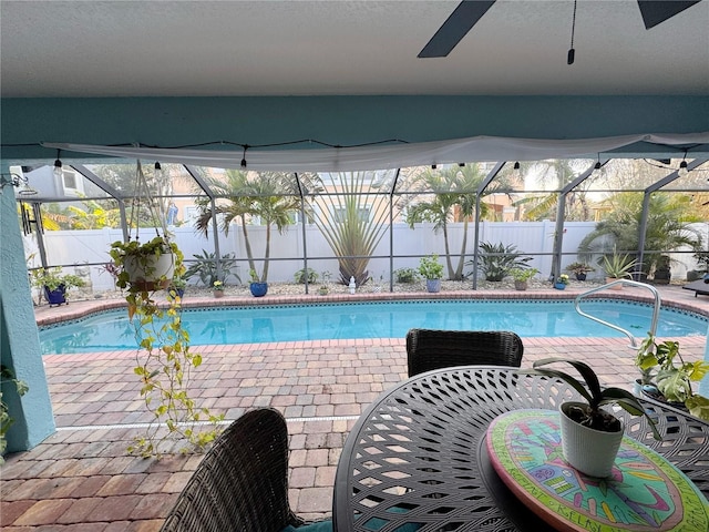 view of swimming pool featuring a patio and glass enclosure