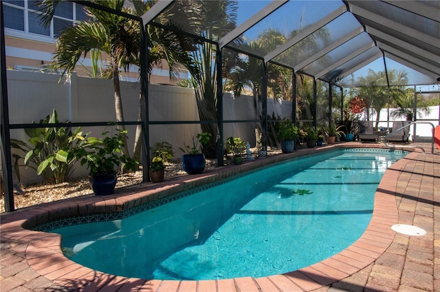 view of swimming pool with a patio and glass enclosure