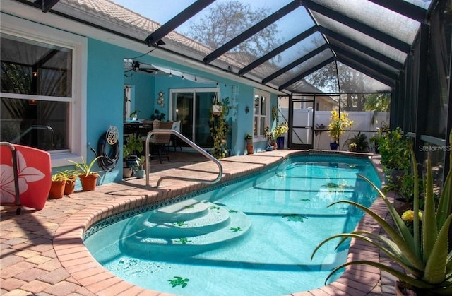 view of swimming pool with a lanai and a patio